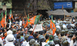 BJP supporters try to break police barricades during the protest rally against failure of...