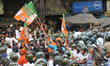 BJP supporters try to break police barricades during the protest rally against failure of...