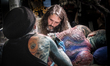 A man receives a tattoo during the Paris Tattoo Convention (Mondial du Tatouage) on March...
