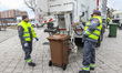 The Suez company grabage collectors (dustmen) emptying waste container into garbage truck...