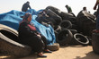 A Palestinian protester collects tyres during a tent city protest at the Israel-Gaza borde...