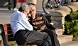 Elderly men sit and talk on a bench during a sunny day in Goksu Park in Ankara on April 22...