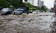 Vehicles and Rickshaws try driving with passengers through the waterlogged streets of Dhak...