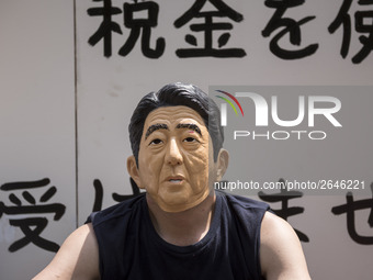Worker wears a mask of Japanese Prime Minister Shinzo Abe during the May Day rally sponsored by the Japanese Trade Union Confederation, know...