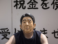Worker wears a mask of Japanese Prime Minister Shinzo Abe during the May Day rally sponsored by the Japanese Trade Union Confederation, know...