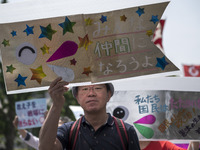 Worker holds placard during the May Day rally sponsored by the Japanese Trade Union Confederation, known as Rengo at Yoyogi Park in Shibuya...