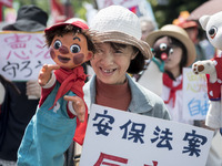 Worker holds placard and puppet during the May Day rally sponsored by the Japanese Trade Union Confederation, known as Rengo at Yoyogi Park...