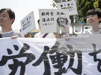 Workers hold placards during the May Day rally sponsored by the Japanese Trade Union Confederation, known as Rengo at Yoyogi Park in Shibuya...