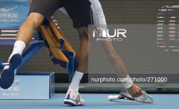 (141003) -- BEIJING, Oct. 3, 2014 () -- Novak Djokovic of Serbia picks up his broken racket during the men's quarterfinal match against Grig...