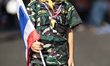 A young boy dressed in camouflage clothes and holding a Thai flag during the second day of...