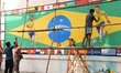 A painter applies finishing touches to an image of soccer player Neymar, on a large Brazil...