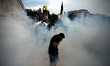Protesters clash with riot police during a demonstration against the agreement between Gre...