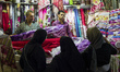Woman choosing textile at the stall in Grand bazaar in Tehran, Iran