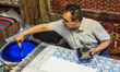 Mohsen, son of Reza Sedighi Fard, master of textile hand printing, stamps pattern on the t...
