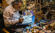Painter-miniaturist Afarinesh Honar makes picture on camel bones, Esfahan, Iran