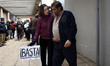 52 year-old Andres Gonzalez Manzano gestures while an activist carrying a banner where it'...