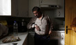 52 year-old Andres Gonzalez Manzano look at his wristwatch in his kitchen as he waits to b...