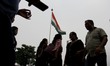People can be seen walking with Indian Flag in the background in New Delhi, India, on 22 J...