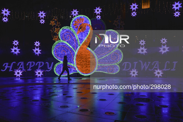 A woman pass by a large peacock decoration inconjuntion Happy Diwali at Subang Jaya,20km from Kuala Lumpur on October 20, 2014.  Diwali is a...