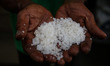 A farmers with his hand show the salt during a harvest at a salt farm in Banda Aceh, Indon...