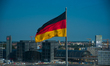 The German flag waves on the top of Reichstag building, house of the German Government in...