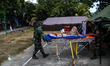 Indonesian police and soldiers evacuate a old man after arriving at Health Facility after...