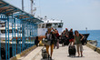 
Foreign tourists carry their belongings on the beach as they leave Gili Trawangan island...