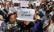 A woman raises a placard which reads “ do not change the words of God” as she attends a de...