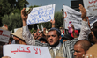 A man holds a copy of the Koran as he attends a demonstration held outside the Assembly of...