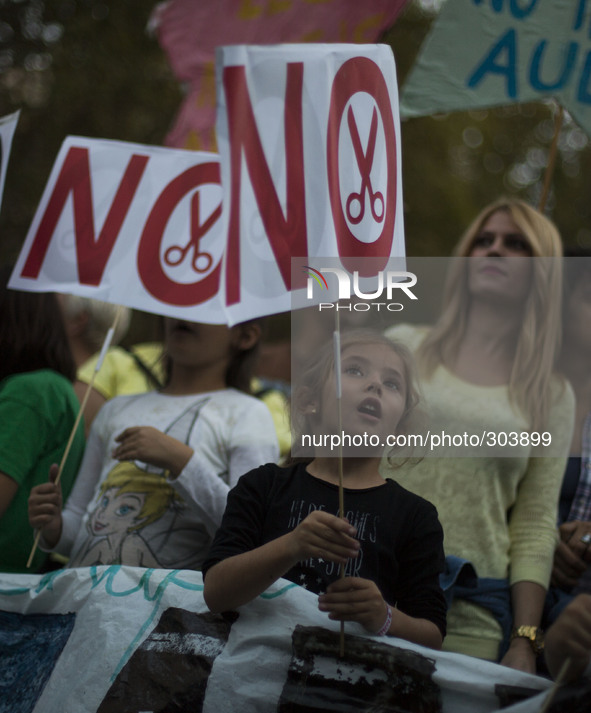 A girl holds a banner where it is written "NO" during a protest against the government education reform and cutbacks in grants and staffing...
