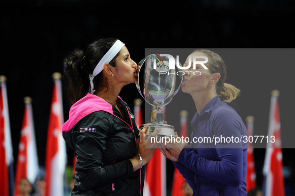 (141026) -- SINGAPORE, Oct. 26, 2014 () -- Cara Black (R) of Zimbabwe and Sania Mirza of India kiss the trophy during the awarding ceremony...