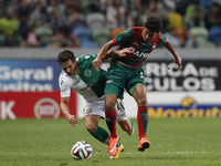 Sporting's defender Cedric (L) vies with Maritimo's midfielder Mohamed Ibrahim (R) during the Portuguese League  football match between Spor...