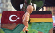 A doll hangs from a fake cannon between the Turkish and the German flag during a demostrat...