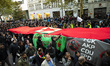 People hold a huge flag of the in Germany forbidden Kurdish organisation PKK  during a dem...