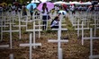 Relatives visit the graves of their loved ones, who perished a year ago during the onslaug...