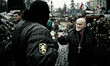Guard man talks to a priest inside the barricade line on Hrushevskoho street 