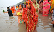 Indian Hindu devotees perform rituals during Chhat Puja while standing in the river in Kol...