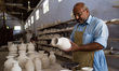 Multan, Pakistan, October 4, 2018. A man holds a vase to check for defects at the Blue Pot...