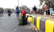 An indian woman worker paints the fringes of a road  for upcoming Kumbh Mela in Allahabad...