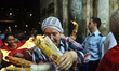 Elderly Christian woman carry candles with fire out of Church of the Holy Sepulchre during...