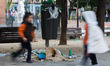 Children run in front of an overflowing trash bin during the fourth day of a garbage colle...