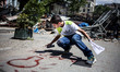 A boy uses spray paint to write graffiti on a road in Taksim Square. Protests entered the...