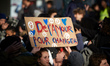 A student holds a placard reading 'Some love to change'. Highschool students and professor...