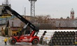 Workers arrange pipes delivered for construction of the South Stream gas pipeline and load...
