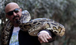 a Palestinian visitor holds a 30 years-old Snake which belongs to the Python snakes at Raf...