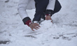 A Nepalese girl collects snow to play with her friends in Chandragiri Hills, Kathmandu, Ne...