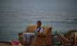 A Palestinian youth sitting outside his family house at Shatti (beach) refugee camp in Gaz...