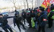 Members of the French anti-riot police CRS stand guard in front of protesters in the stree...