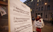 A half dozen people are seen gathered in front of the state broadcaster TVP Info headquart...