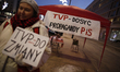 A half dozen people are seen gathered in front of the state broadcaster TVP Info headquart...